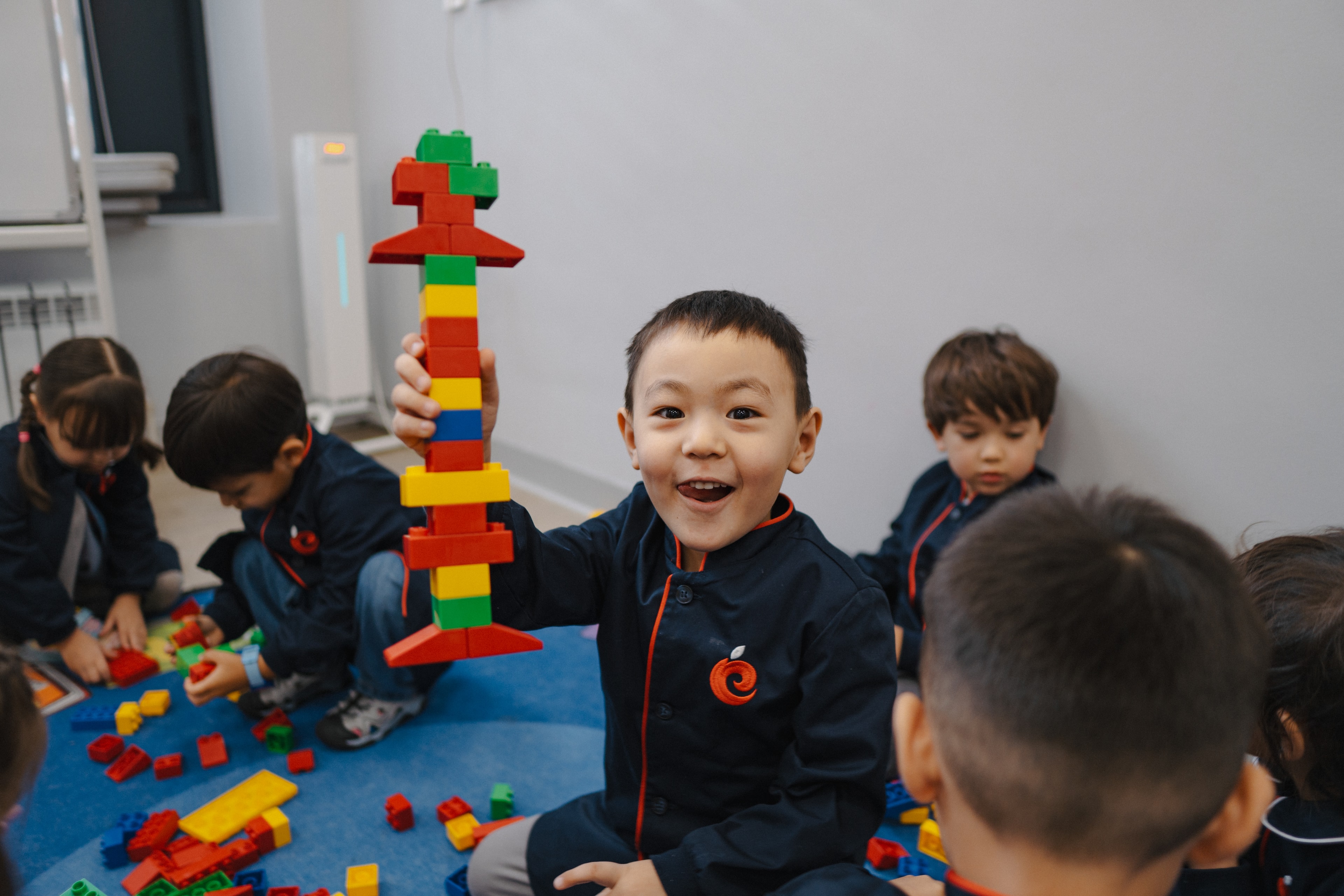 Children playing in a colorful, sunlit classroom